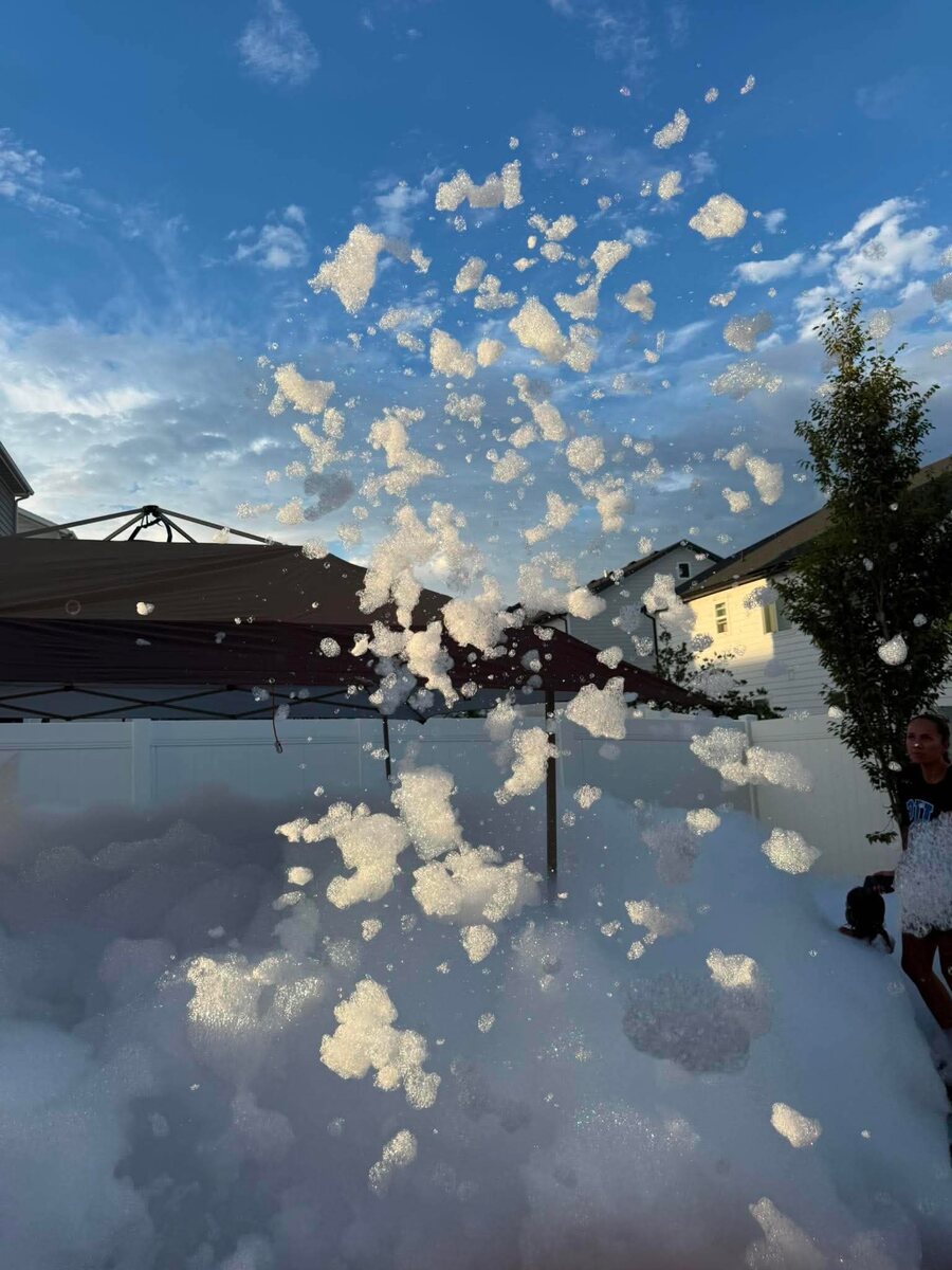 Foam bursting high into the sky above a backyard canopy